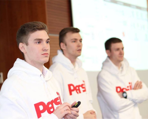 Três funcionários da Henkel vestindo um suéter Persil e realizando uma apresentação
