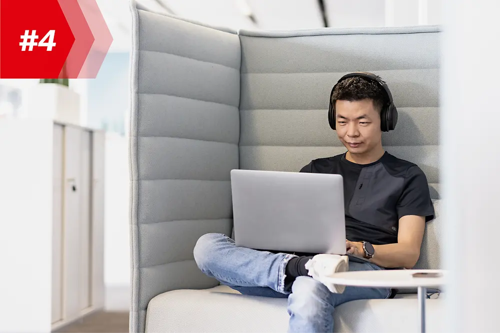 Funcionário da Henkel Hao, Chefe da Fábrica de Aplicativos Móveis, com fones de ouvido e seu laptop