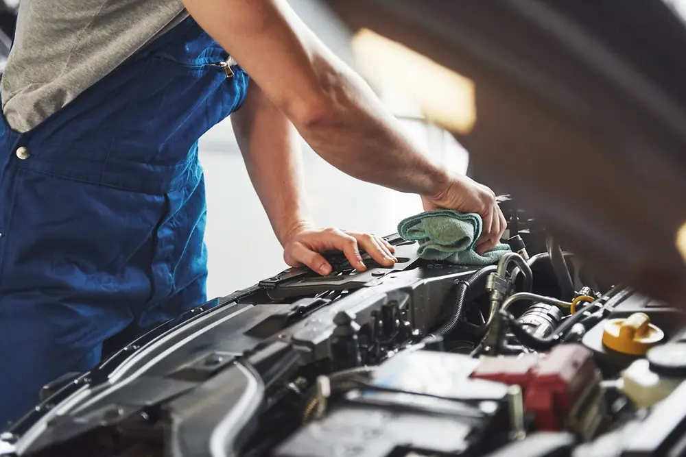 Homem mexendo em motor de carro