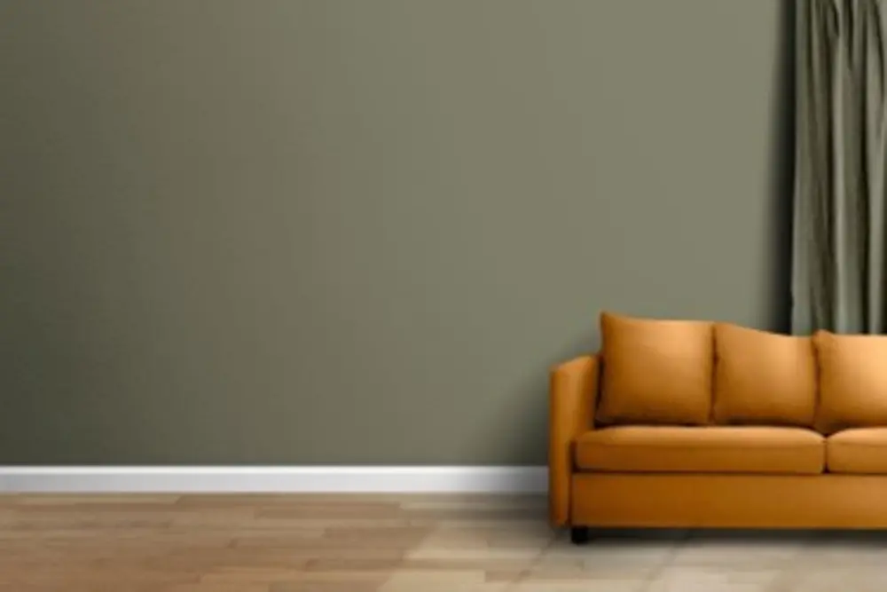 Rodapé branco, parede verde e sofá amarelo
