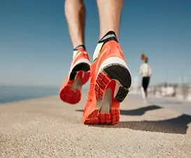Imagem de uma pessoa correndo com um tênis laranja
