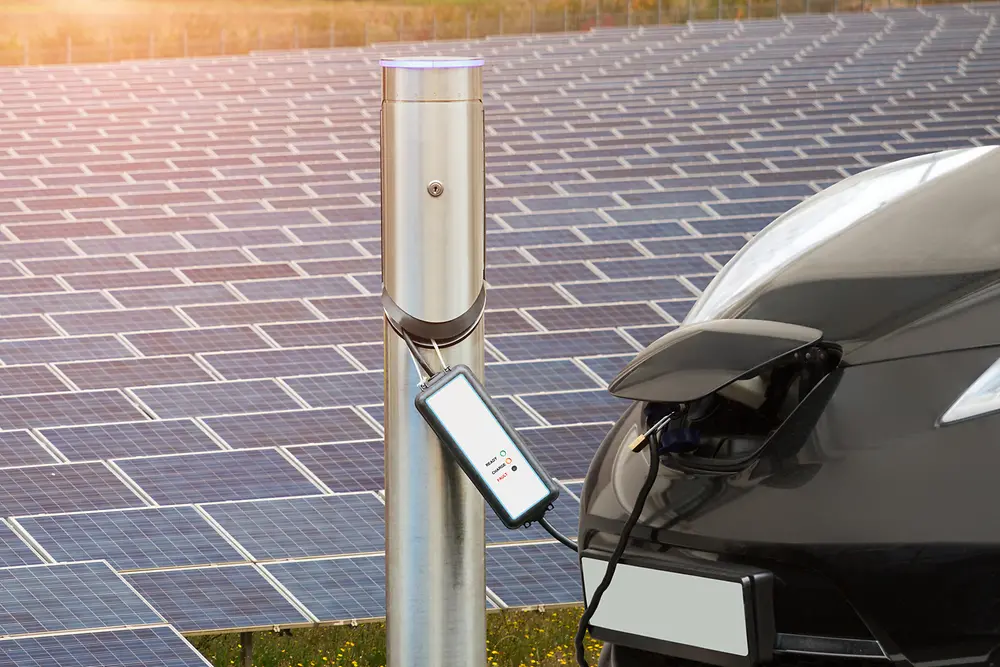 Carro elétrico em frente a um campo de painéis solares