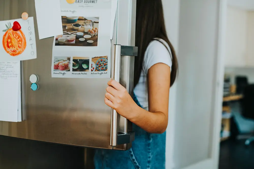 Imagem de uma mulher abrindo a geladeira