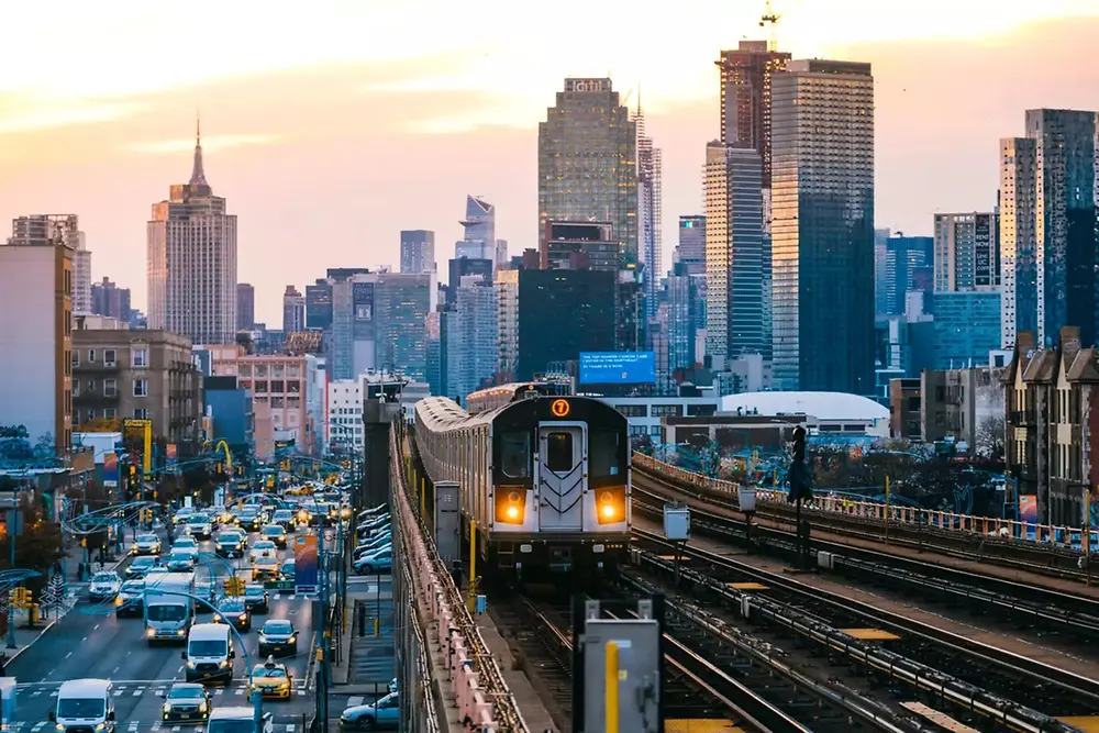 Trem urbano percorrendo o horizonte de uma cidade moderna durante o dia.