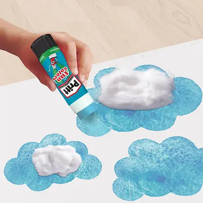 Uso da Cola Pritt Fun Color azul em um trabalho artístico com algodão e desenho de uma nuvem em um papel branco.