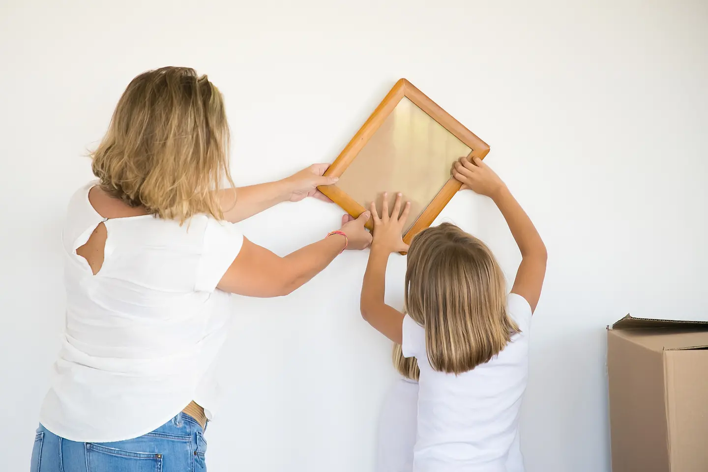 Mãe e filha realizando uma colagem na parede