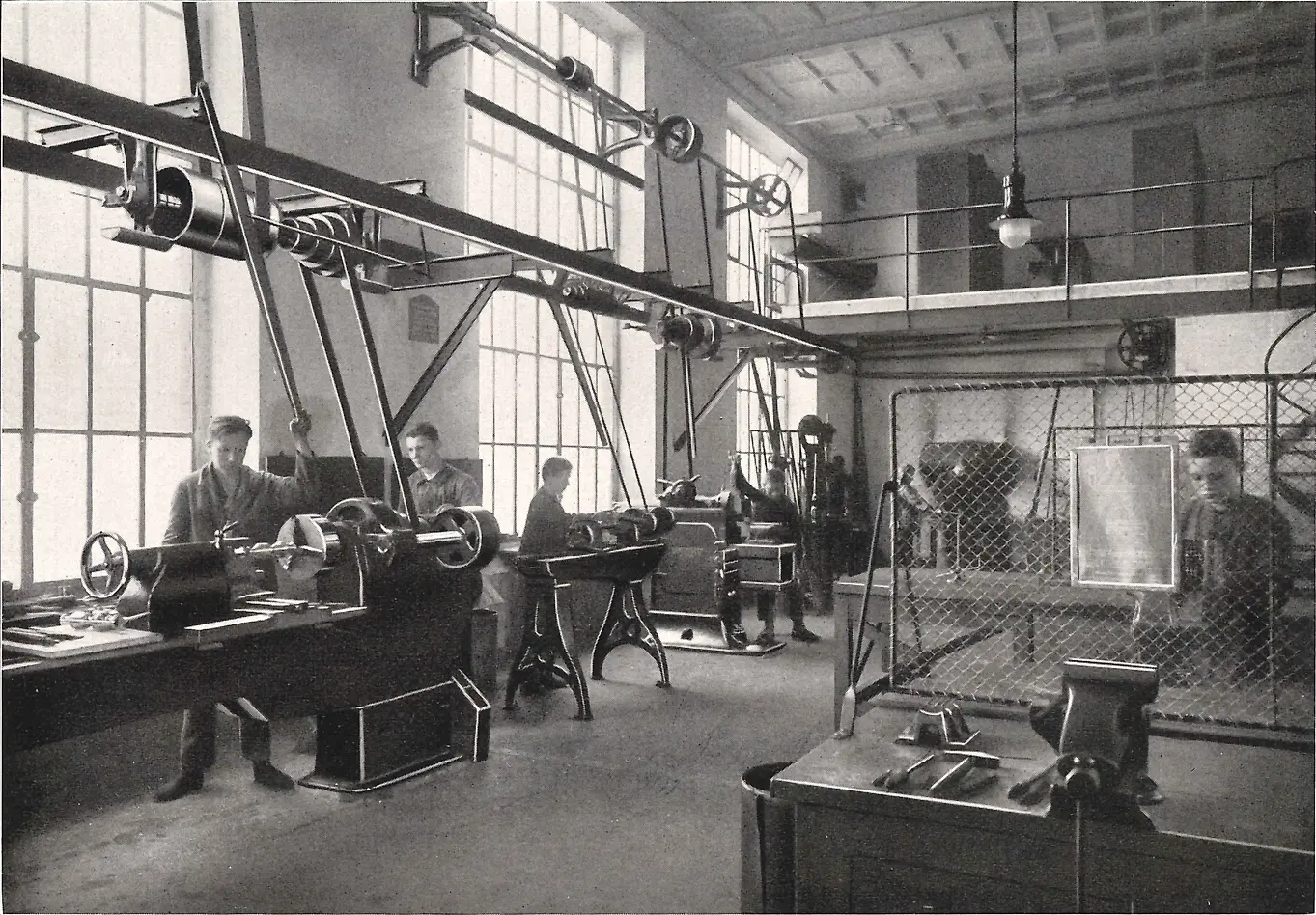 Aprendizes trabalhando em máquinas na oficina de metalurgia.