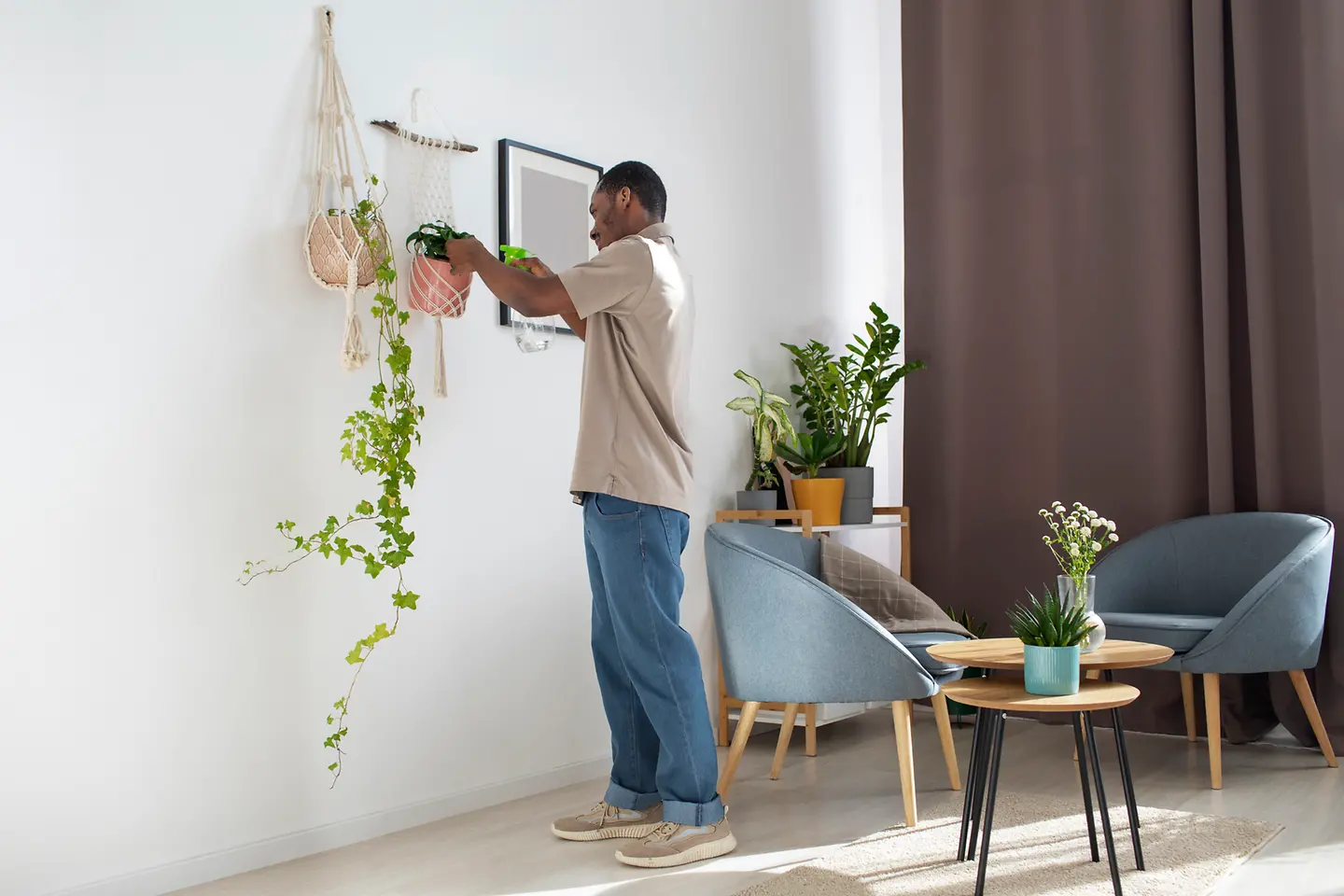 Decorador em pé ajusta itens na sala durante a montagem do ambiente.