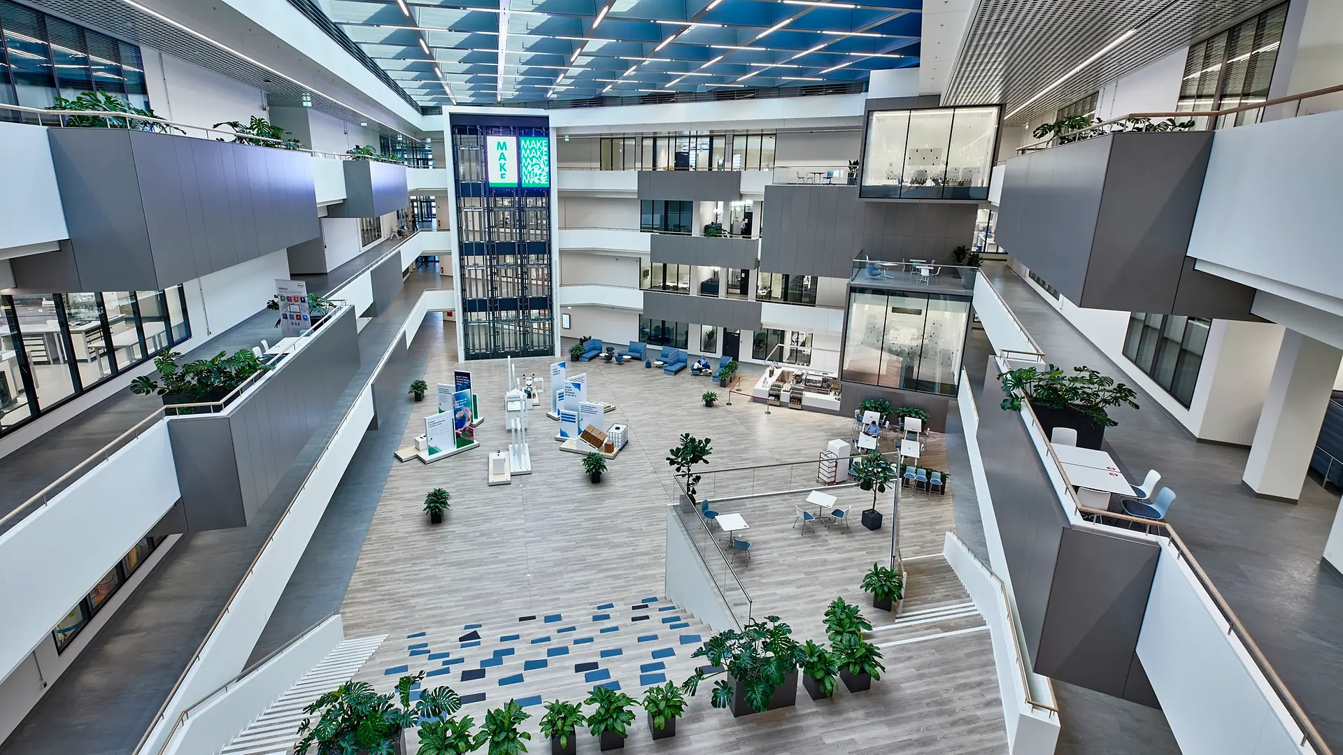 Vista interna do Inspiration Center Düsseldorf com o grande pátio central. A imagem também mostra os laboratórios de alta tecnologia com fachada de vidro distribuídos em quatro andares.