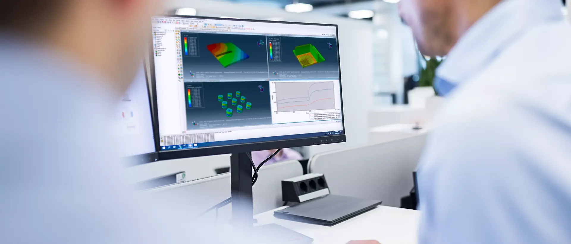 Dois especialistas concentram-se em um monitor de computador que exibe um software de modelagem e simulação 3D em um escritório moderno. A cena transmite concentração e colaboração.